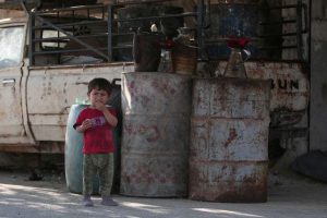 A boy stands near fuel containers in Manbij, in Aleppo Governorate, Syria, August 9, 2016. REUTERS/Rodi Said